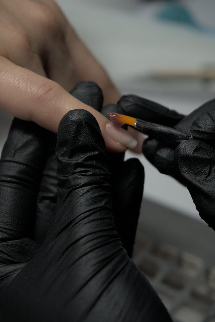 Detailed image of a nail technician applying polish with precision.